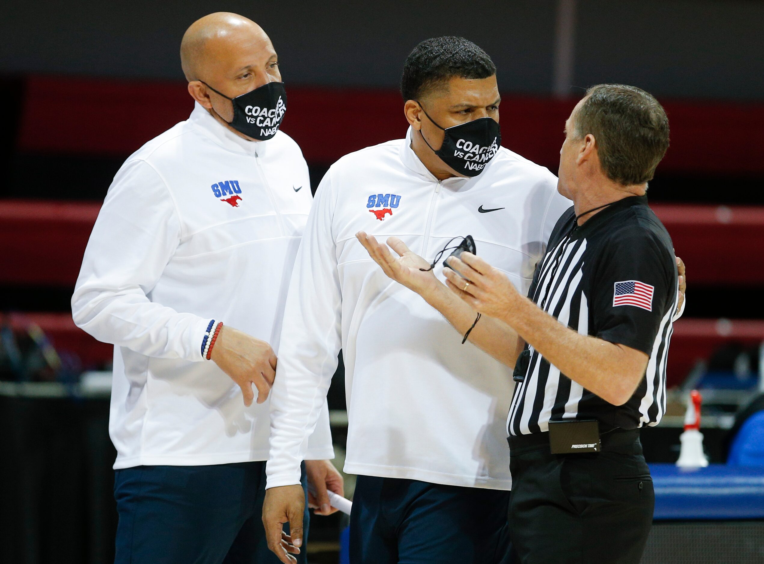 SMU assistant coach Yaphett King, center, listens to the referee explain a call during the...