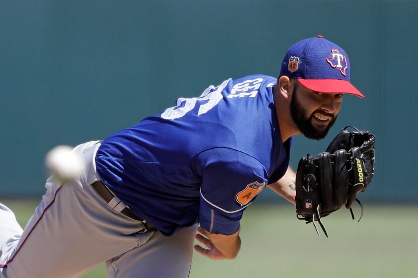 Texas Rangers' Dillon Gee throws during the third inning of a spring training baseball game...
