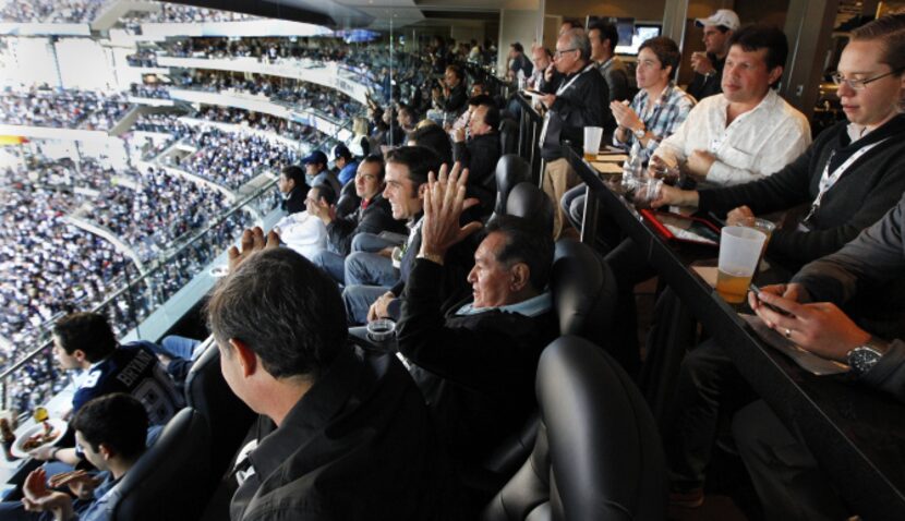 Rafael Melgoza (center), with hands in the air, reacts to a Dallas Cowboys touchdown in a...