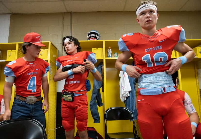Borden County football players listen to coach Trey Richey in the locker room as they get...