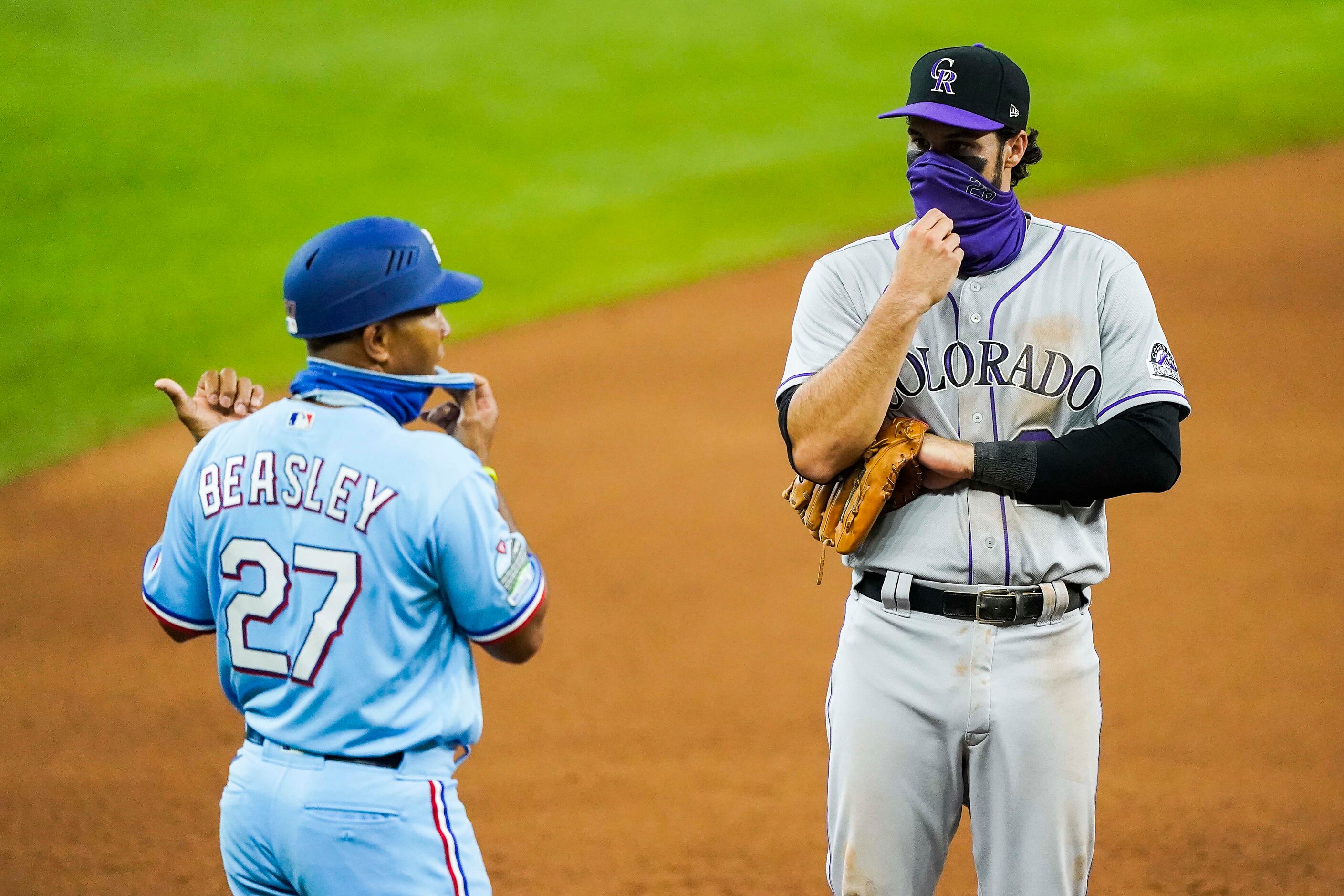 Texas Rangers third base coach Tony Beasley talks with Colorado Rockies third baseman Nolan...