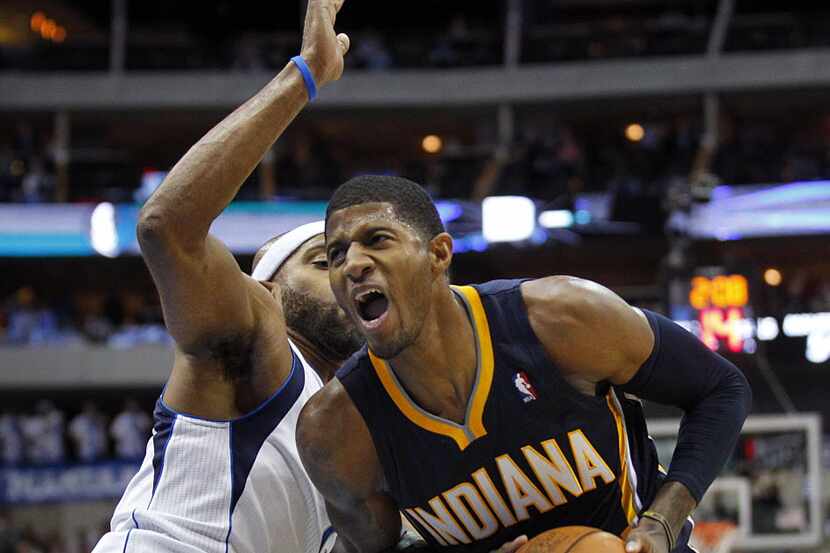 Indiana Pacers shooting guard Paul George (24) tries to clear some room for a shot as Dallas...