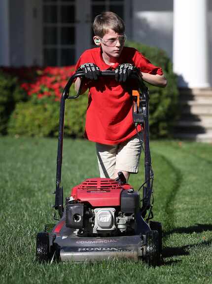 11-year-old Frank "FX" Giaccio mows the grass in the Rose Garden of the White House...