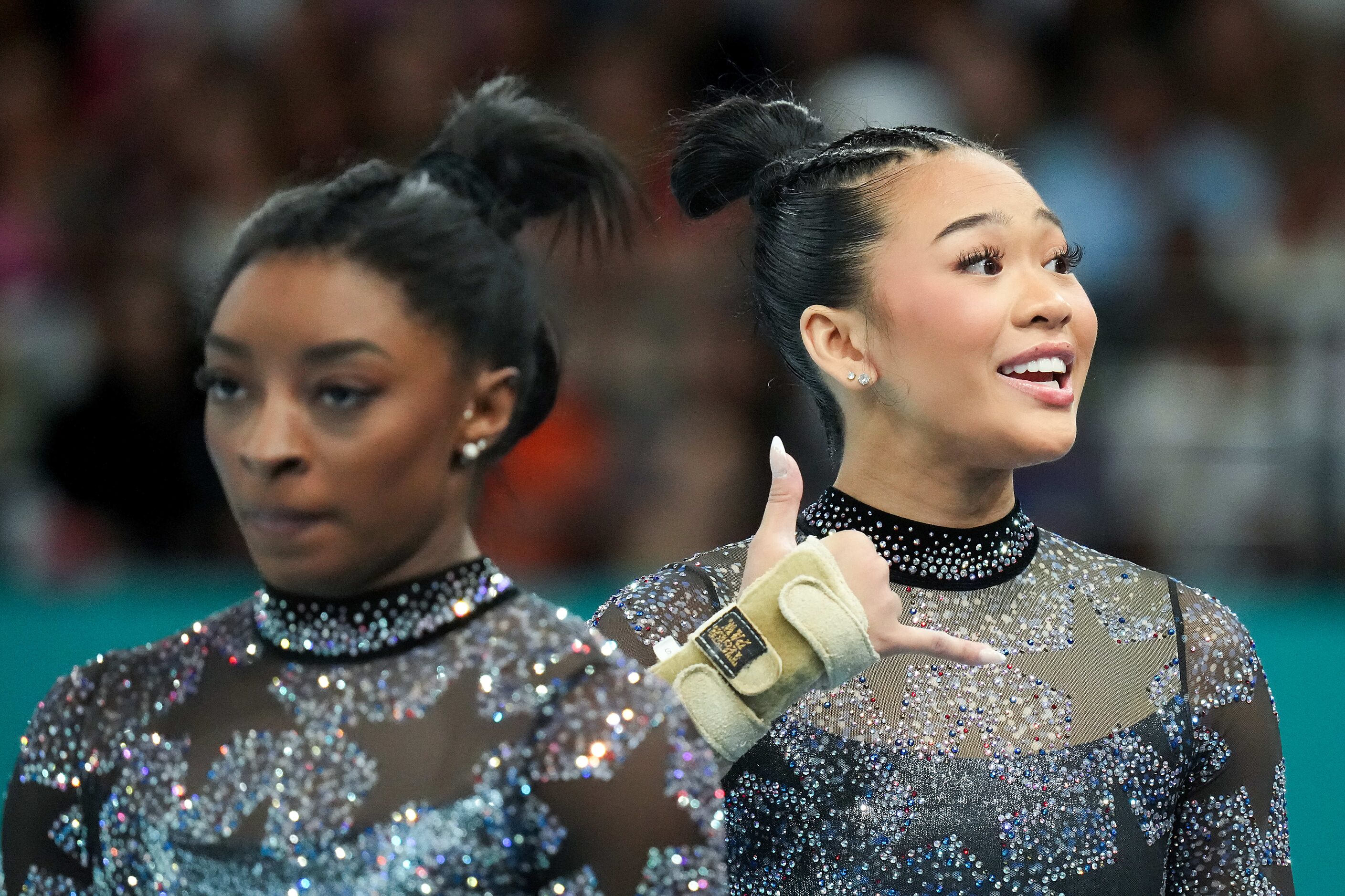 Suni Lee of the United States motions to the crowd as she rotates between apparatus with...