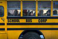 FILE - Another day begins on the yellow bus, as children peer through fogged-over windows on...