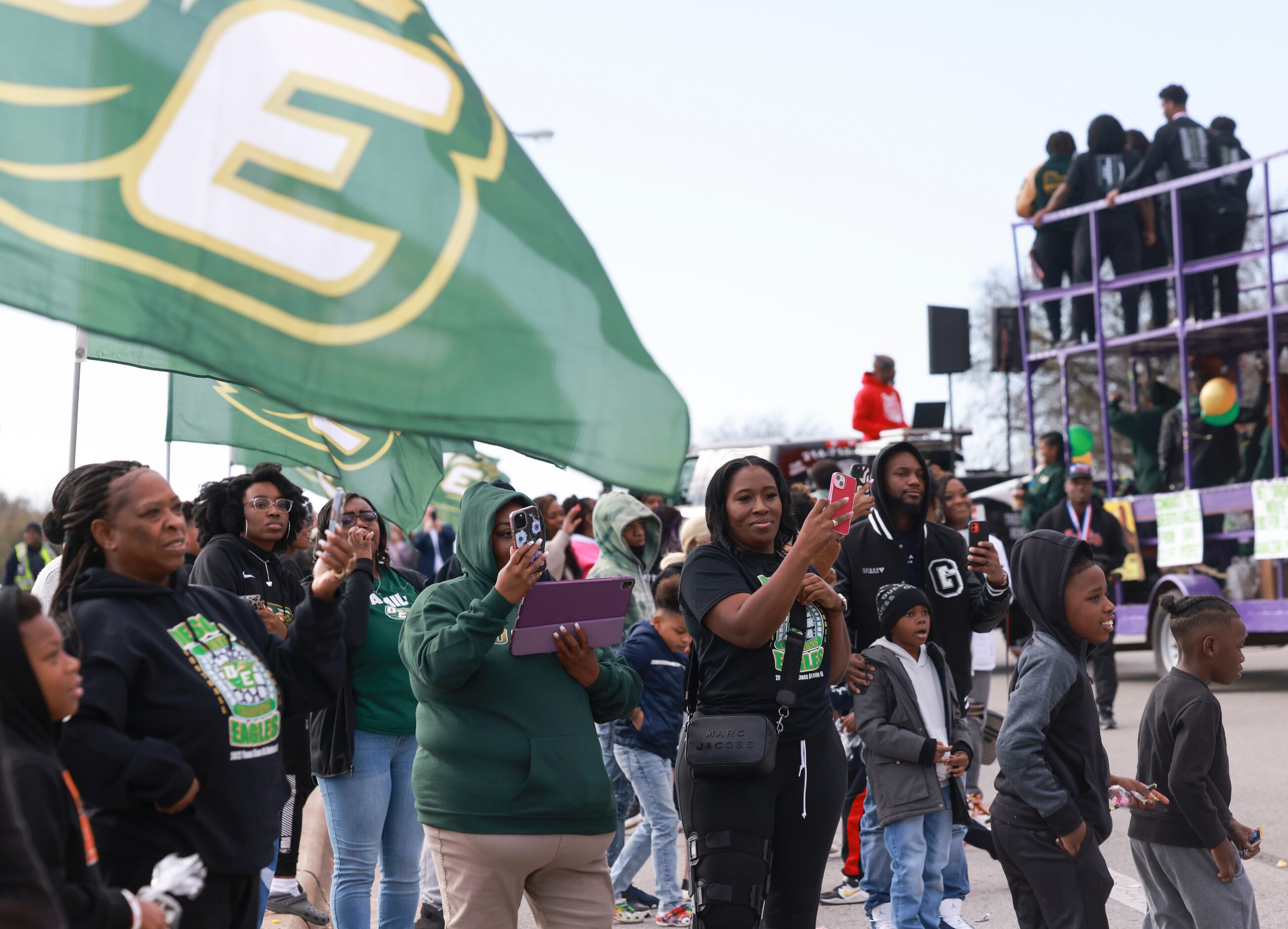 DeSoto High School football fans take videos of players riding on top of double-decker...