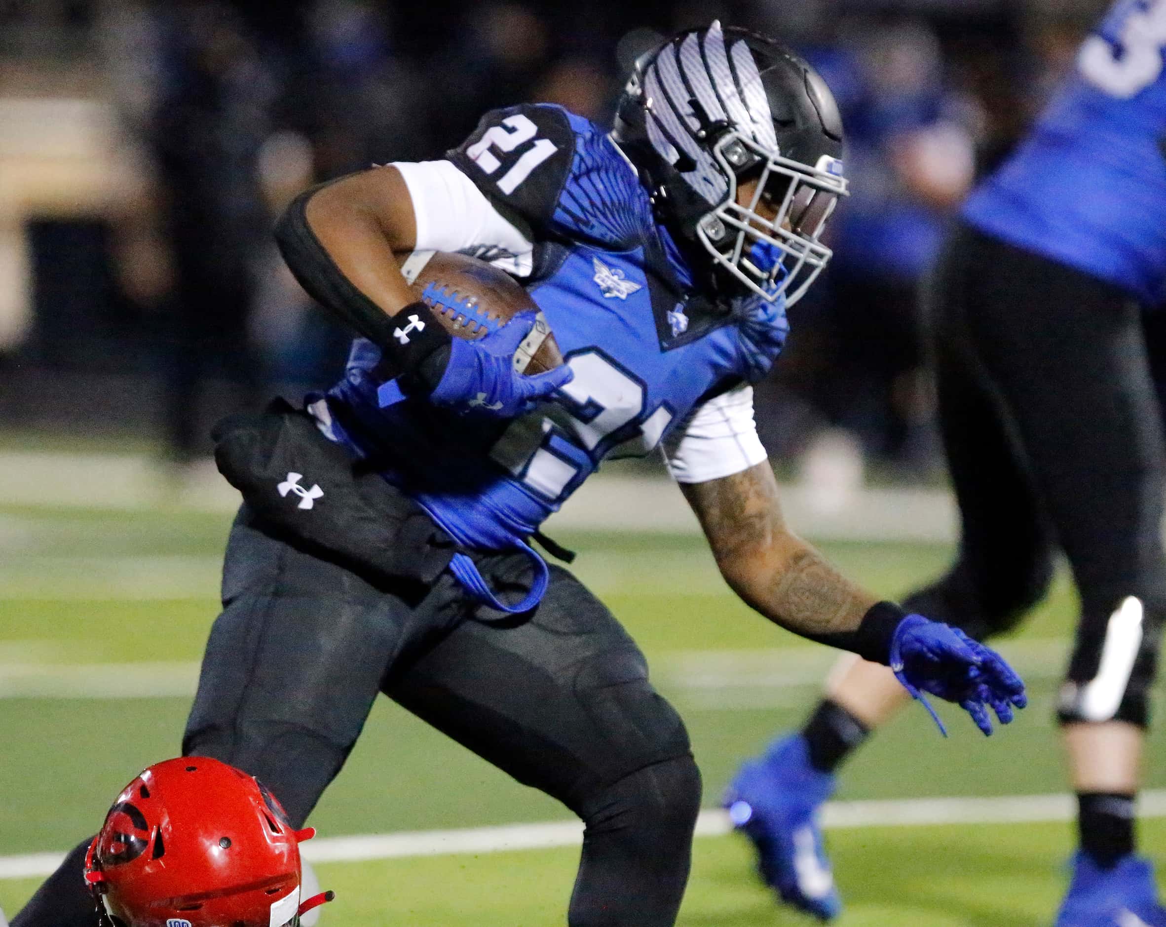 North Forney High School running back Ty Collins (21) drags a would be tackler for extra...