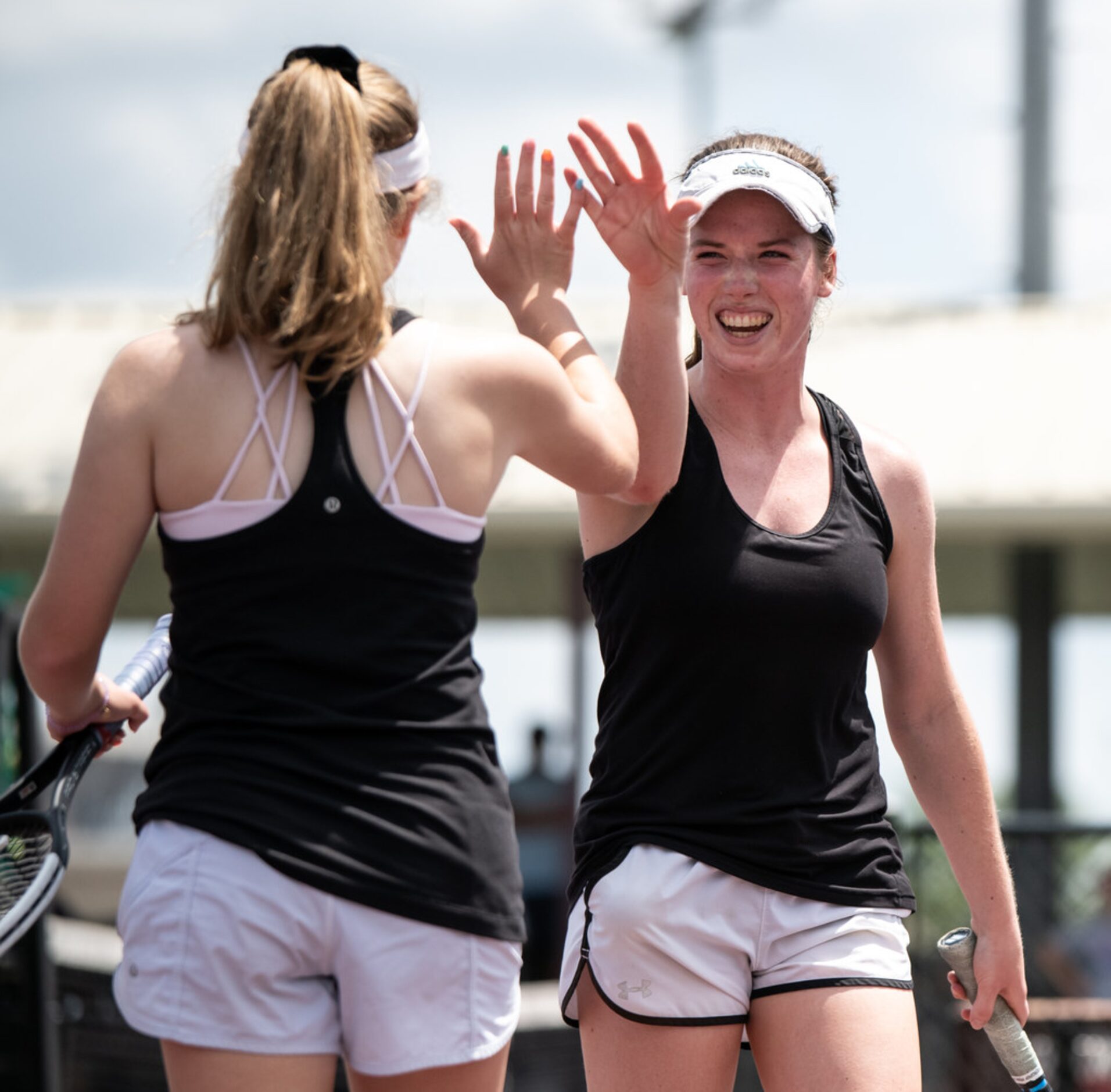 Southlake Carroll's Samantha Lowe and Brennan Becicka high five during a doubles match...