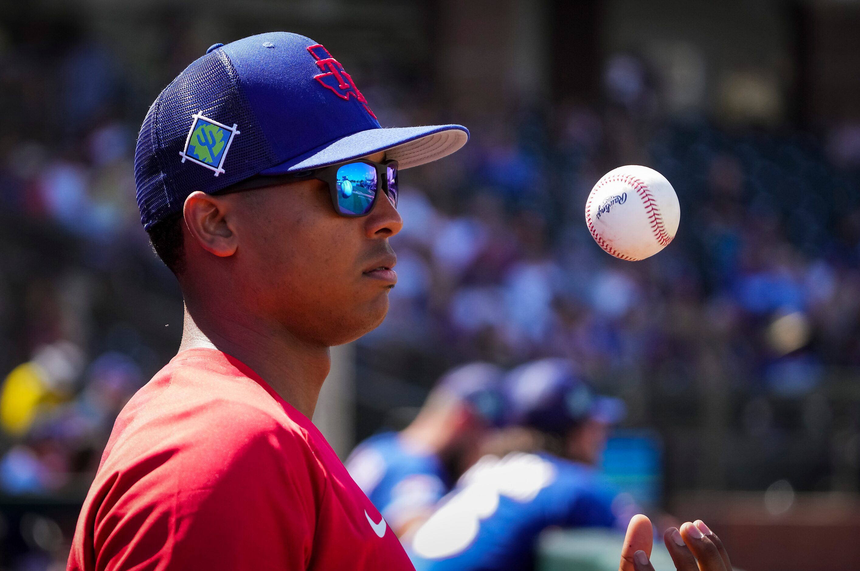 Texas Rangers pitcher José Leclerc tosses a ball in the dugout during the third inning of a...