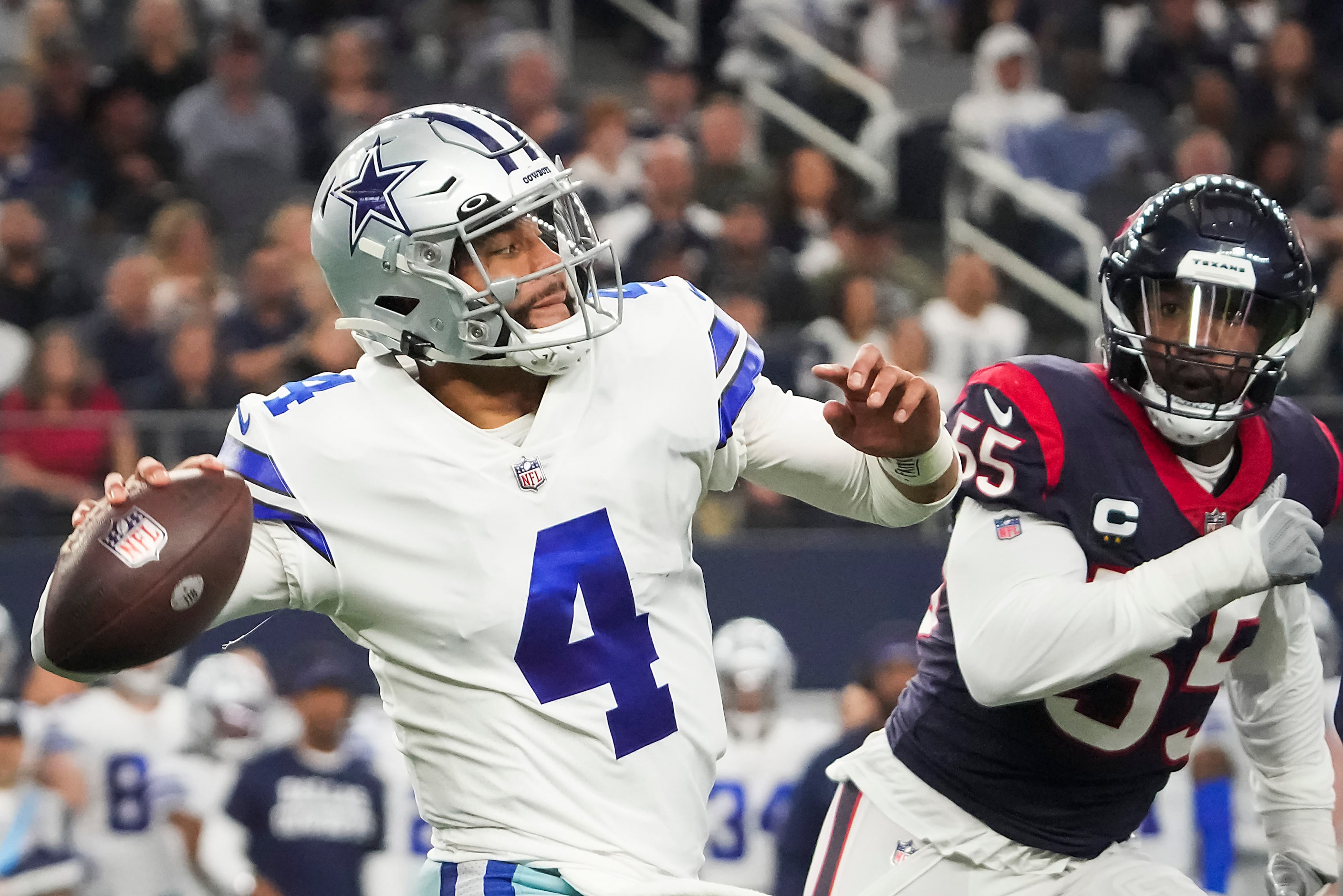 Dallas Cowboys quarterback Dak Prescott (4) throws a pass under pressure from Houston Texans...