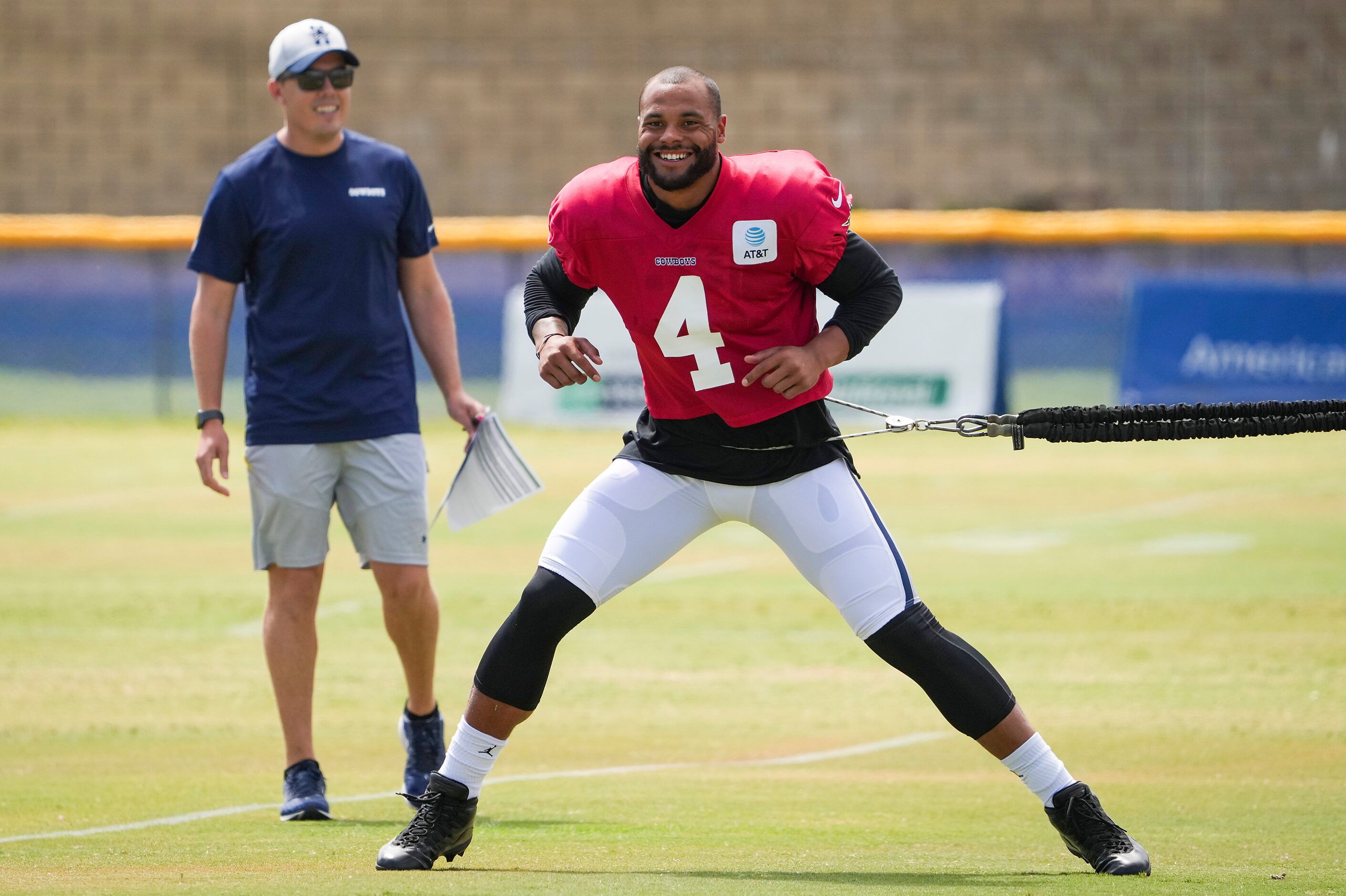 Dallas Cowboys quarterback Dak Prescott (4) stretches as offensive coordinator Kellen Moore...