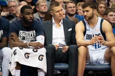 Dallas Mavericks forward Kristaps Porzingis (center) sits on the bench with guard Tim...