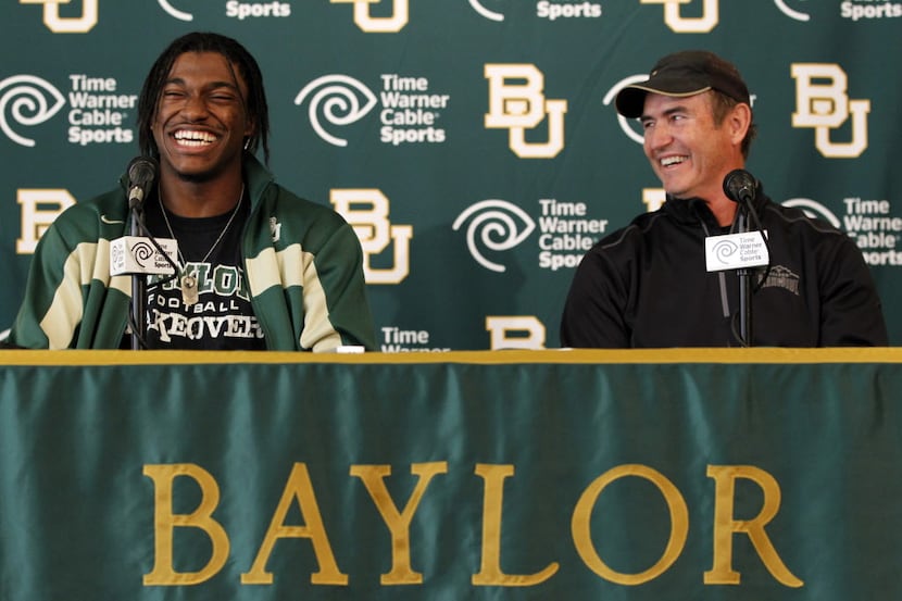 Baylor University quarterback Robert Griffin III and head coach Art Briles share a laugh as...