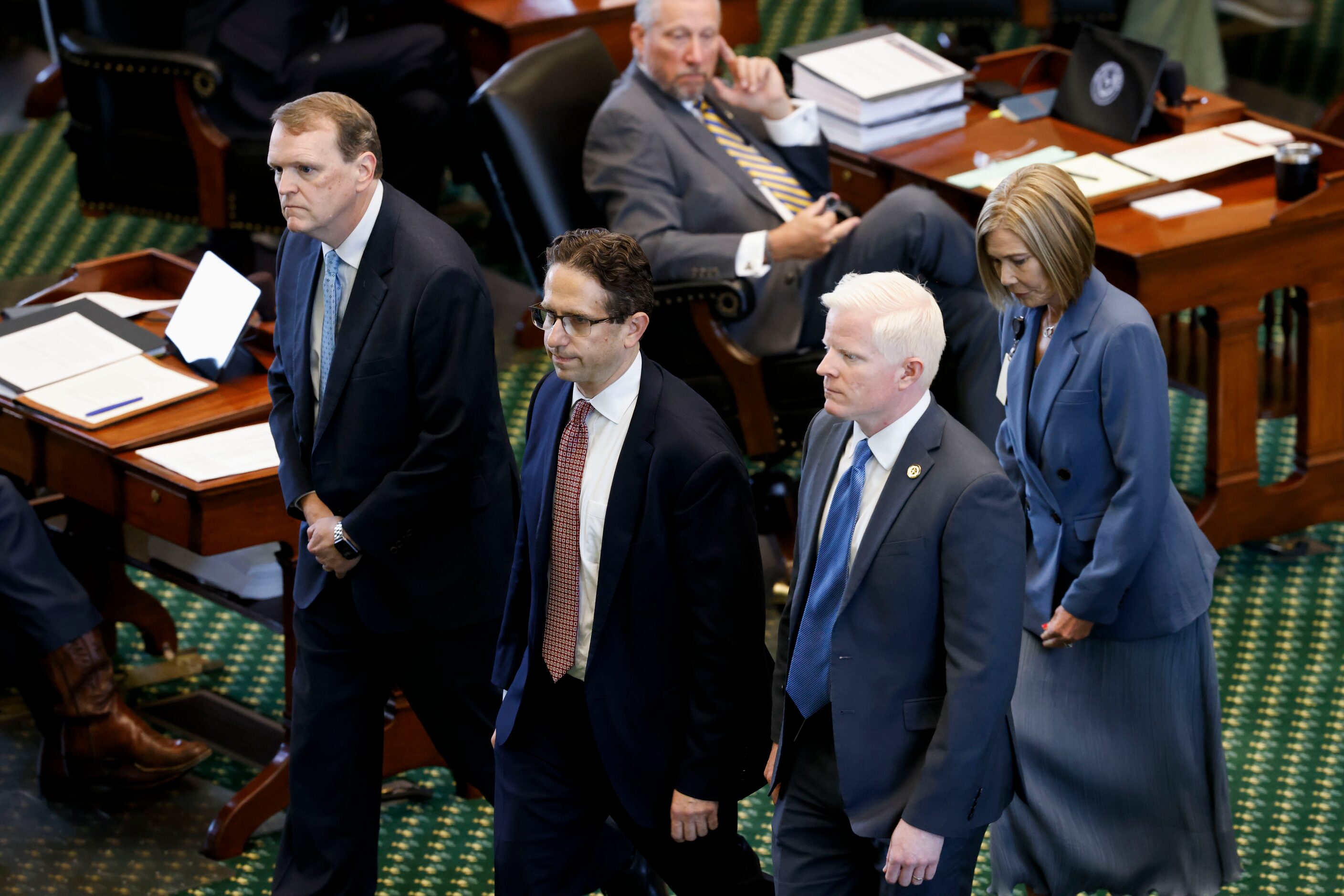 Witnesses walk out of the Senate chamber after being sworn in during the first day of Texas...