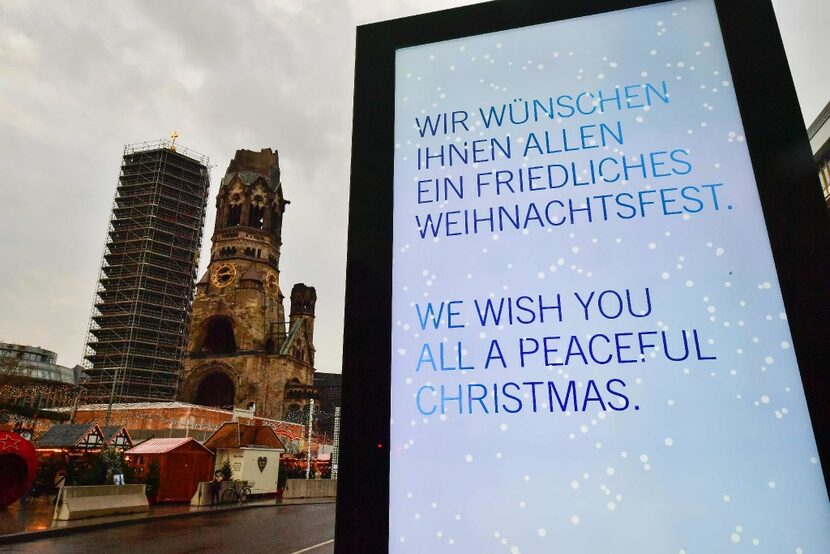 This picture shows a Christmas placard and a view of the Christmas market area near the...