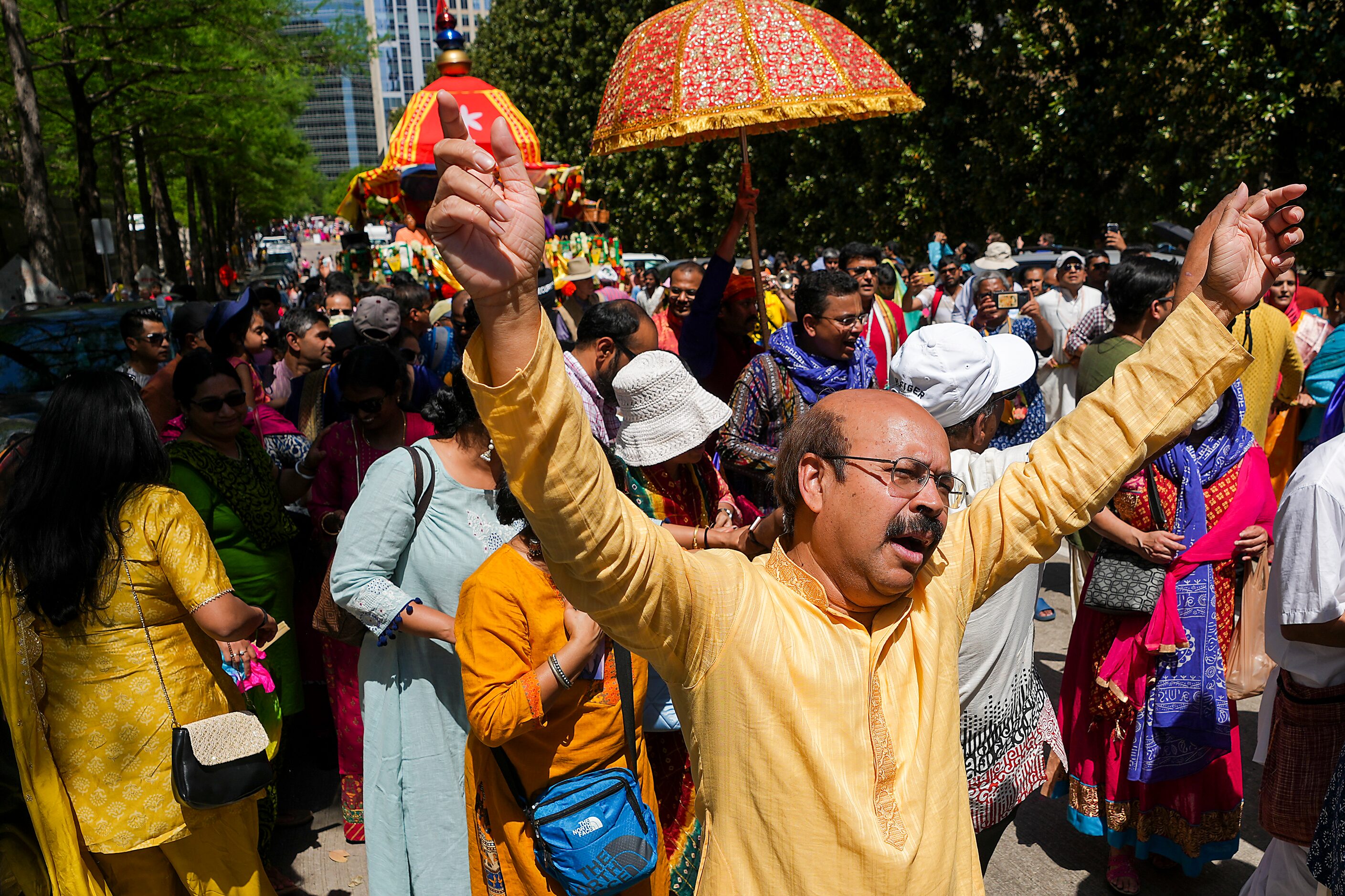 Revelers participating in the Ratha Yatra parade dance down Harwood Street downtown during...