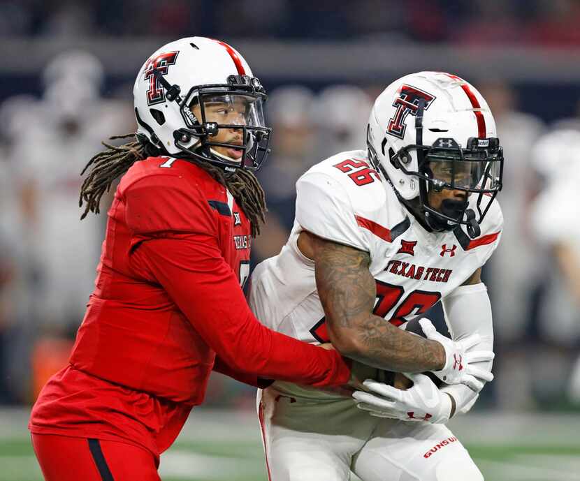 Texas Tech's Jett Duffey (7) hands the ball off to Ta'Zhawn Henry (26) during an NCAA...