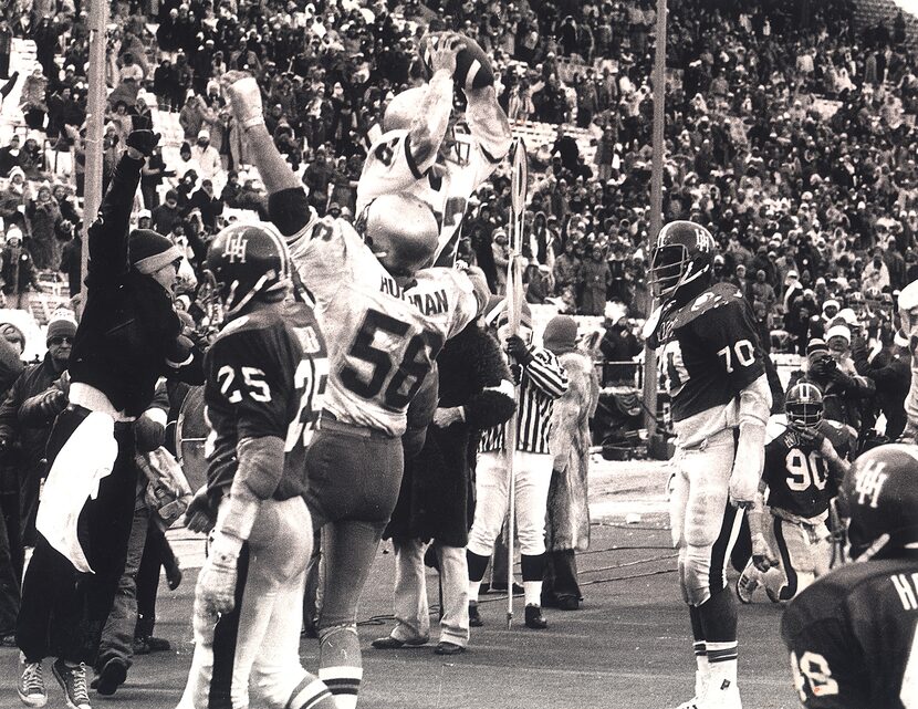 Notre Dame's split end, Kris Haines, holds the ball high overhead after catching a touchdown...