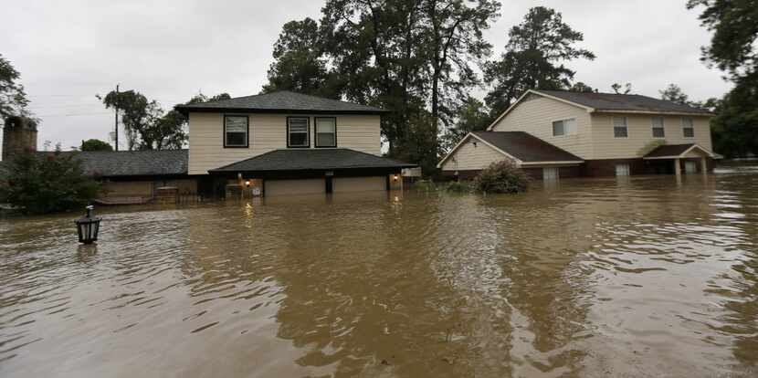 Floodwaters from Harvey surrounded homes Monday in Spring.