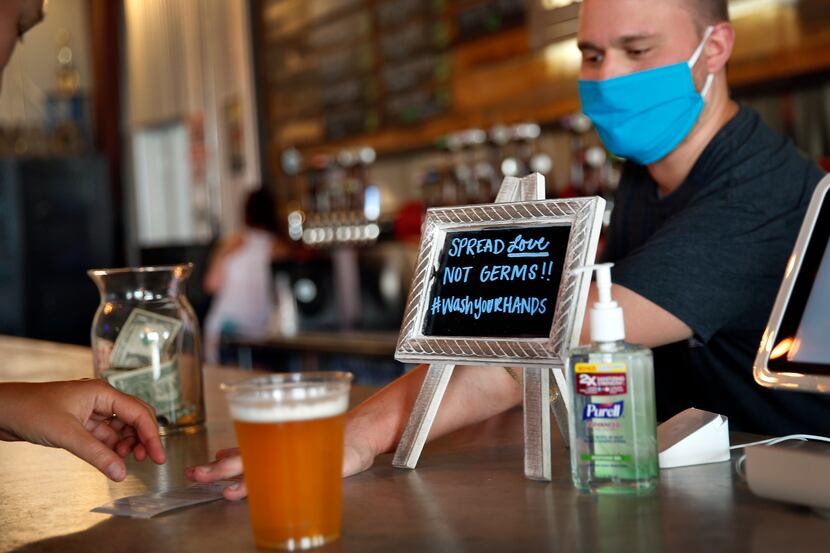Patrons return to the Legal Draft in Arlington, Texas with a bar sign reminding them to...