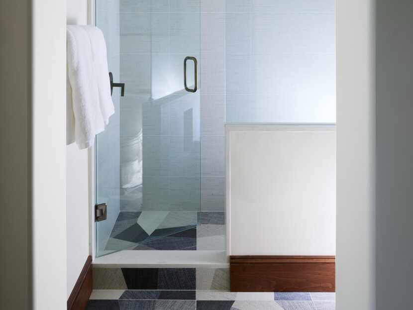 Shower and bathroom floor composed of black, white and gray tiles laid in an unexpected...