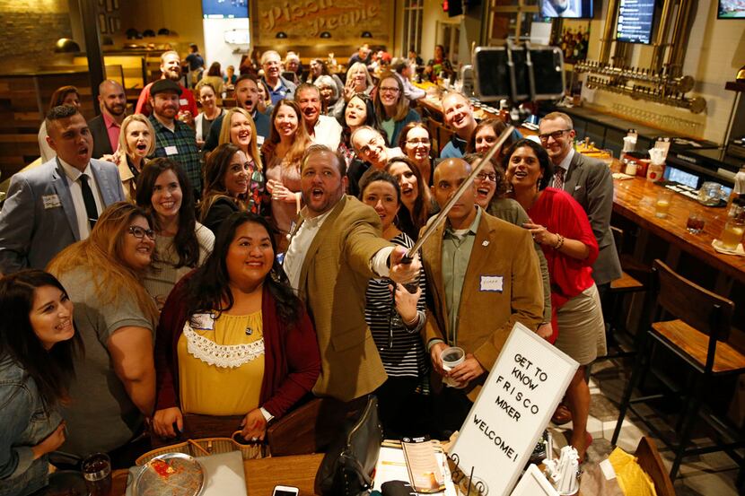 Darin Newbold takes a group photo with people at a Get to Know Frisco mixer at Rotolo's...