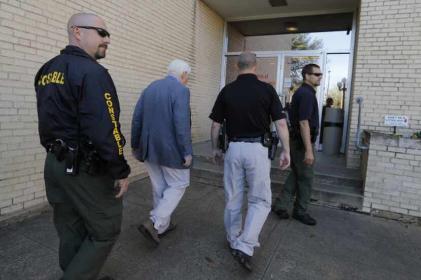 Kaufman county law enforcement officials escort an employee inside the Kaufman County...
