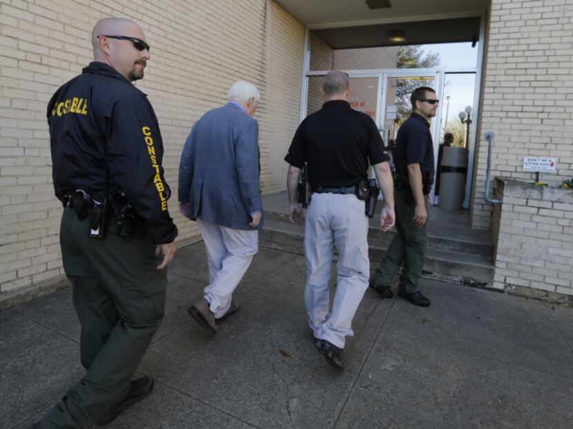 Kaufman county law enforcement officials escort an employee inside the Kaufman County...
