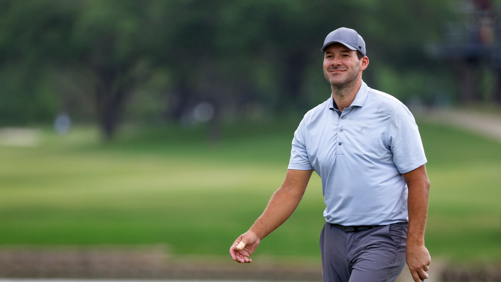Former Dallas Cowboys quarterback Tony Romo smiles after a putt on the 18th green during the...
