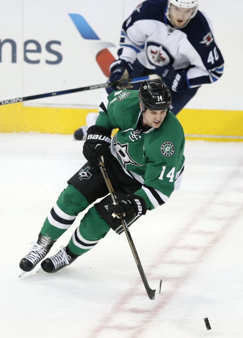 Dallas Stars left wing Jamie Benn (14) advances the puck in a game against the Winnipeg Jets...