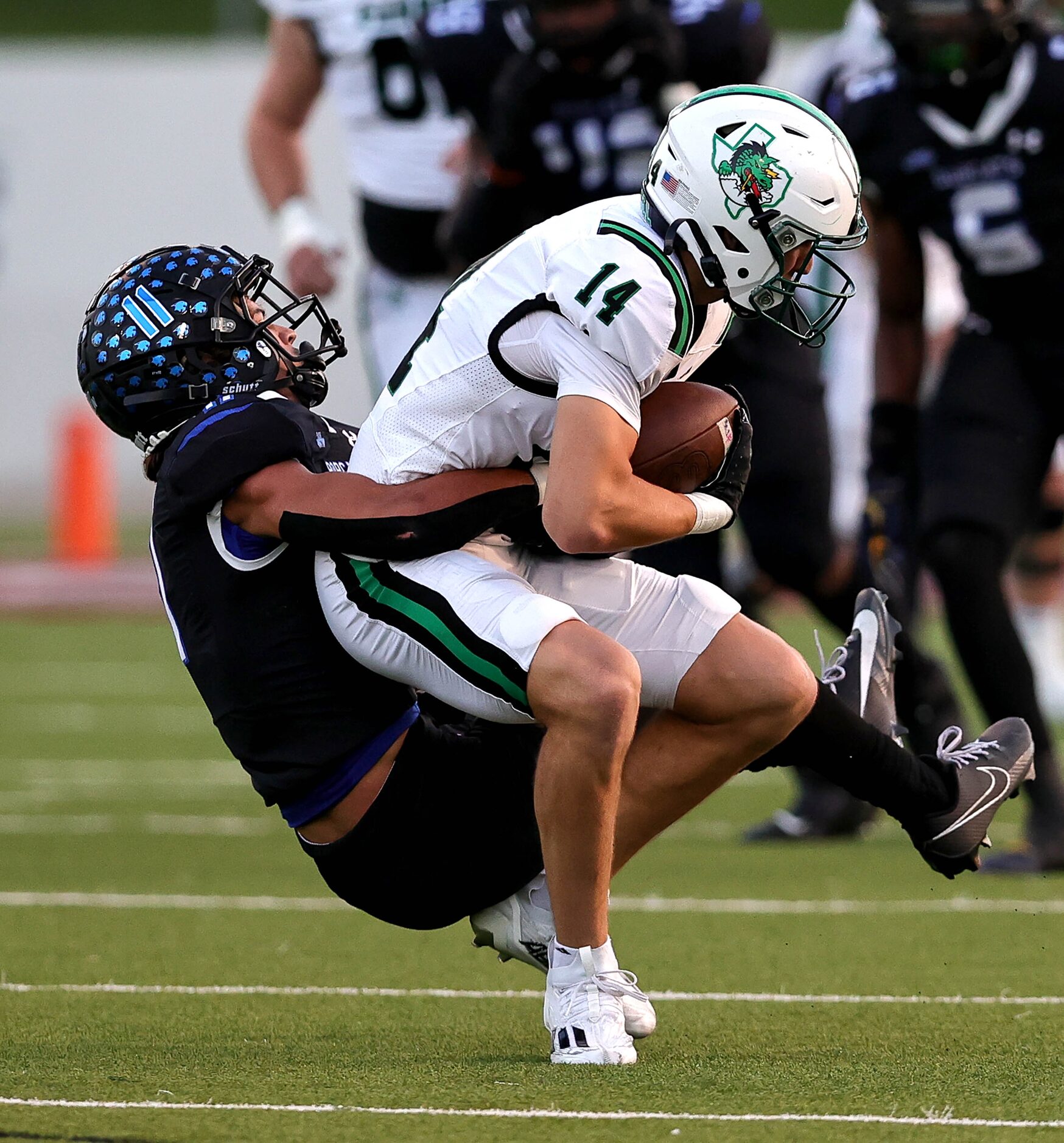 Byron Nelson linebacker Leo Almanza (left) pulls down Southlake Carroll wide receiver...