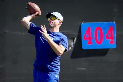Texas Rangers pitcher Max Scherzer tosses a football in the outfield during a spring...