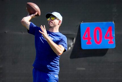 Texas Rangers pitcher Max Scherzer tosses a football in the outfield during a spring...