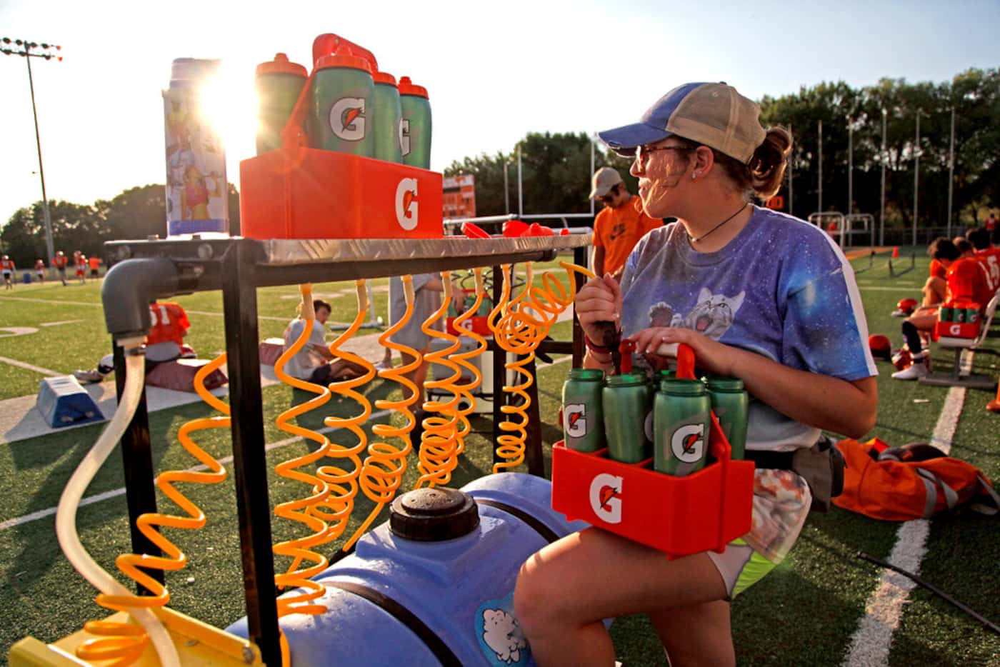 Student athletic trainer Jamie Owen, 16, readies a water station before practiceduring the...