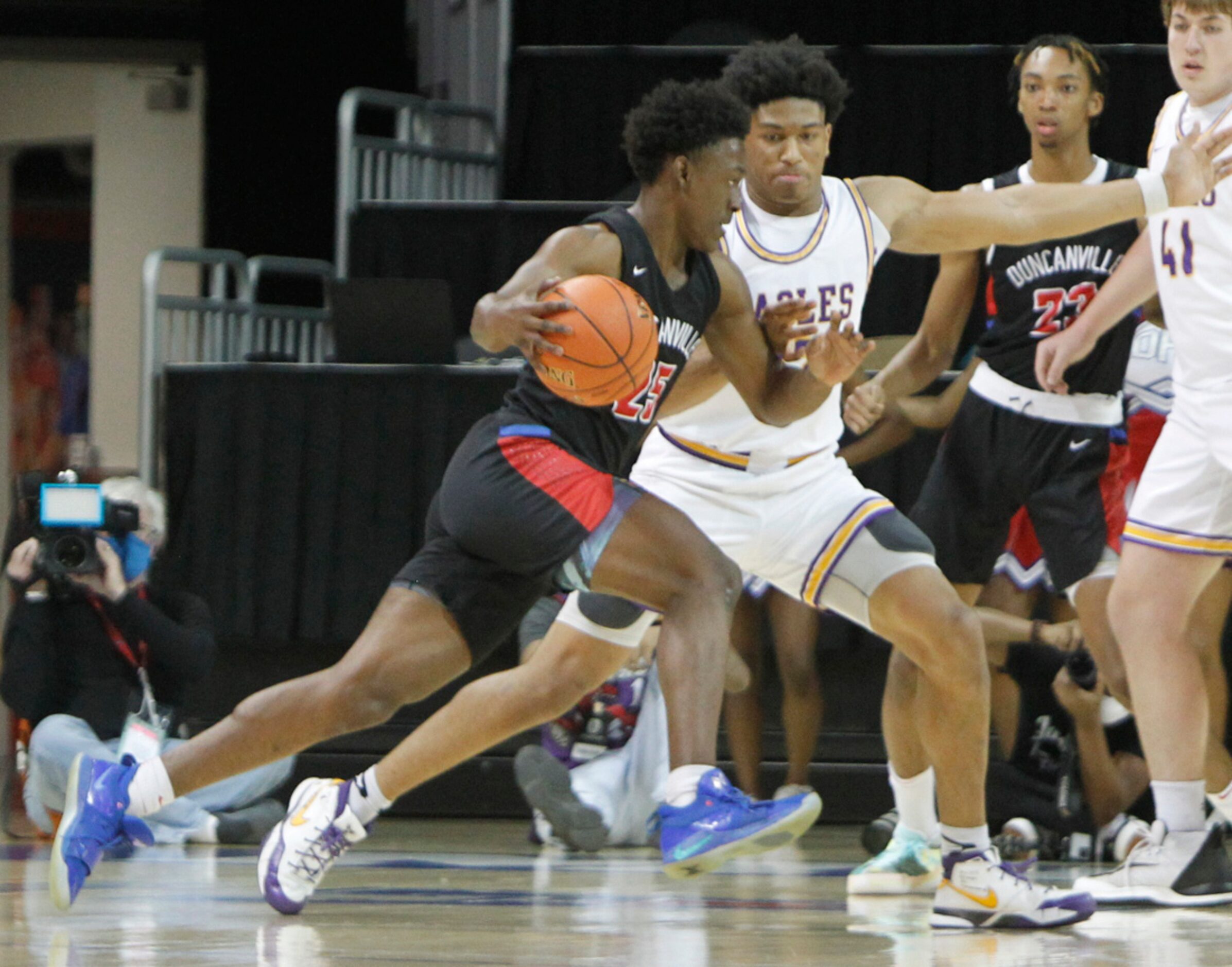 Duncanville guard Damon Nicholas (25) drives hard in the lane as he is defended by...