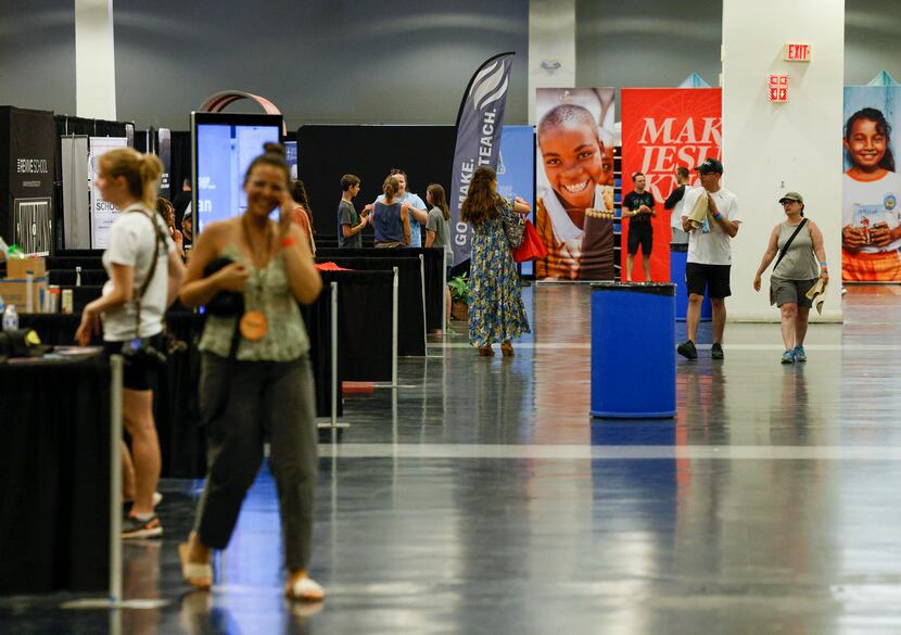 Attendees visit different booths in an exhibit hall at the Together '22 religious revival at...