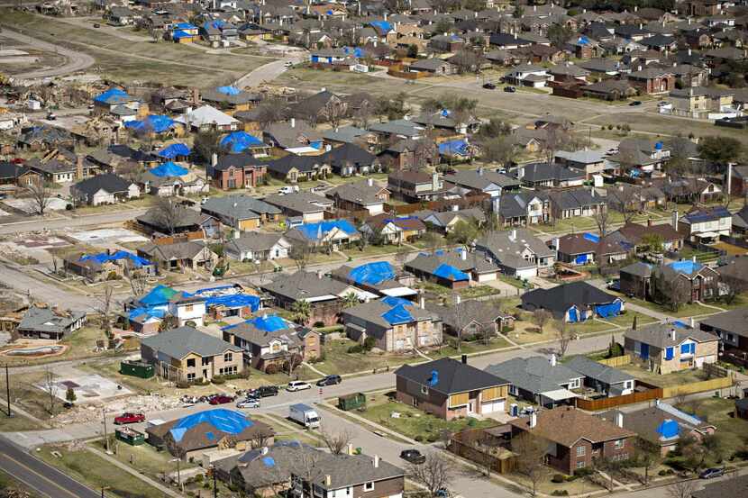 Blue tarps dot rooftops of tornado damage neighborhoods in Rowlett in February.