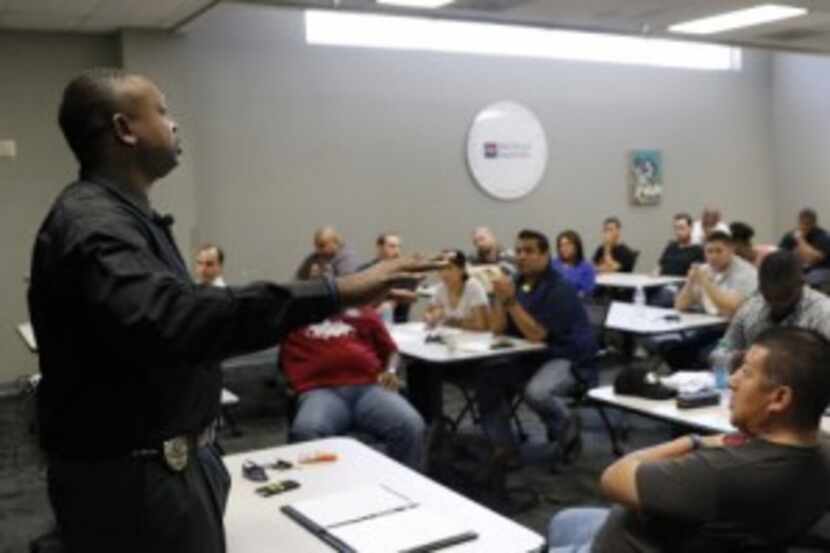  DISD police Sgt. Roderick âTreâ Montgomery, left, teaches situations using âverbal...