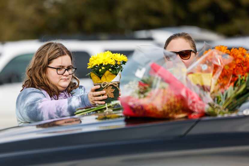 Audrey Hansen, 16, brings flowers with her mother Nicole Hansen, 46, to the Memorial outside...