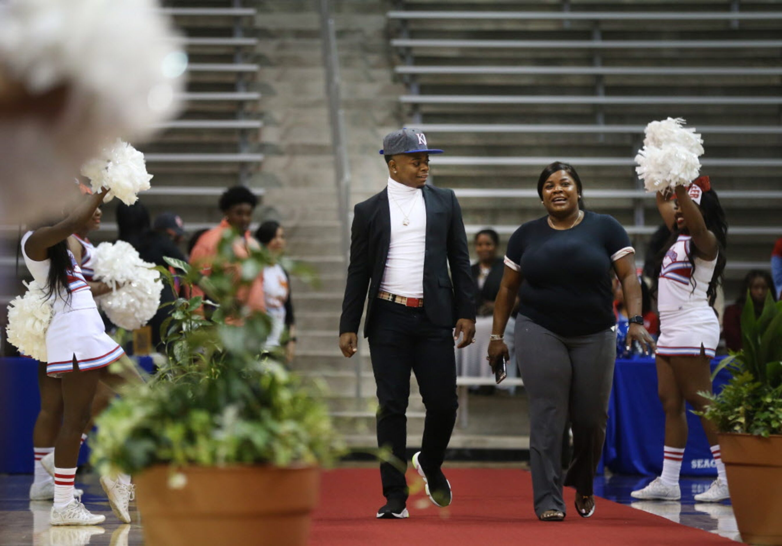 Skyline quarterback Velton Gardner, who signed with University of Kansas, walks with his...