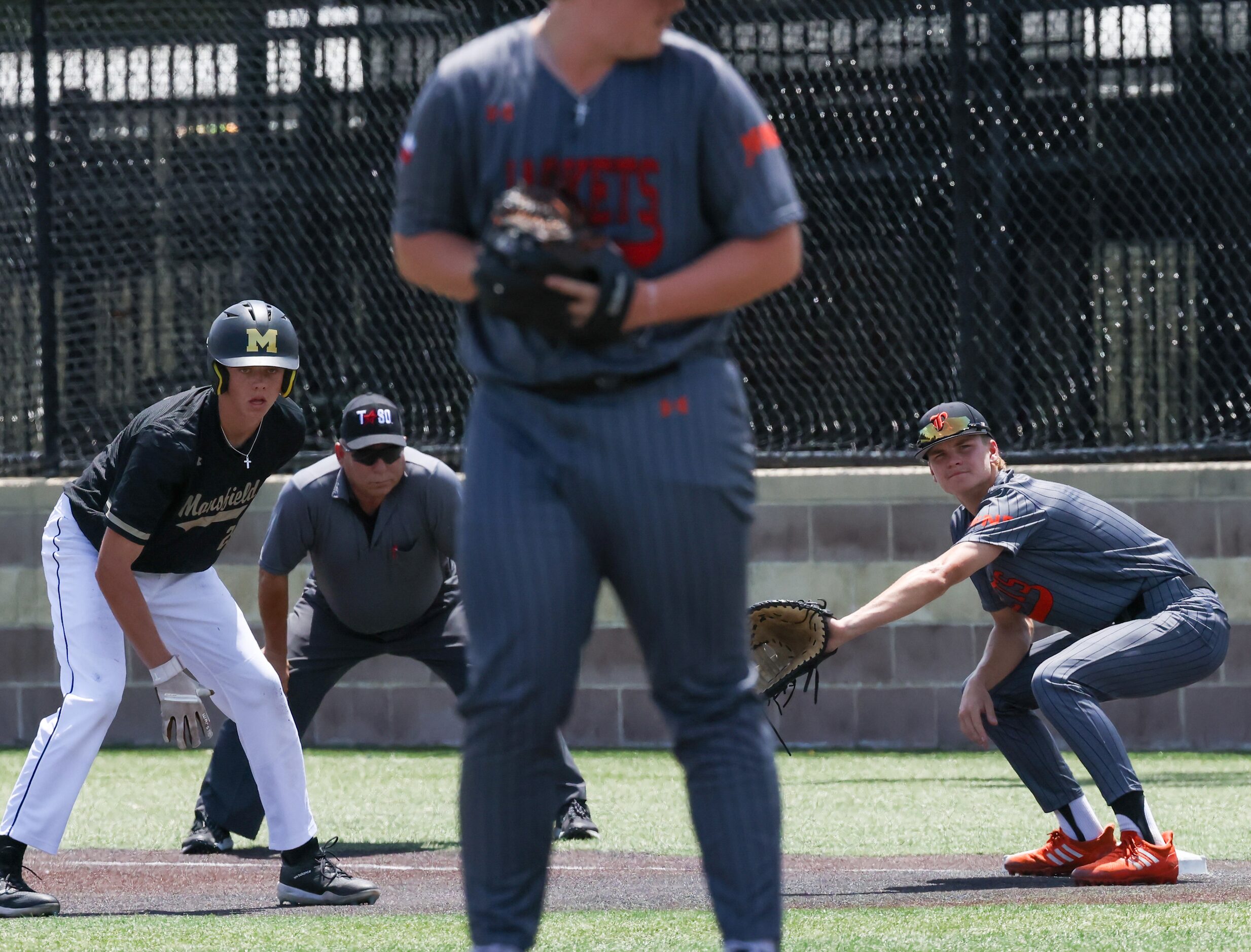 Mansfield left fielder Jaxson Wylie (21, left) steps off first base in preparation of the...