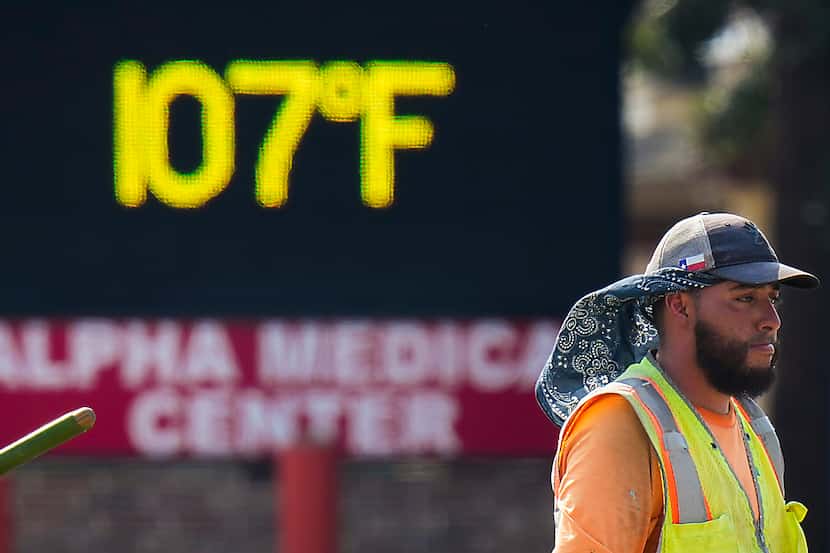 The sign on a business reads 107° as Diego Cardenas works on a construction project in the...