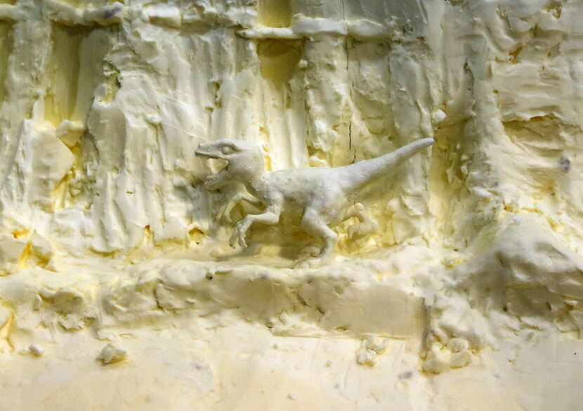 A little dinosaur close to the bottom of a butter sculpture in the Creative Arts building at...