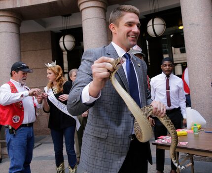 Texas Rep. Jeff Leach, holding a rattlesnake in the outdoor rotunda at the Texas Capitol,...