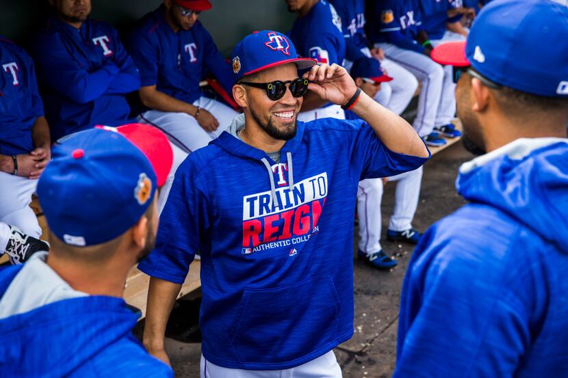 Texas Rangers catcher Robinson Chirinos (61, center) shows off his shades to starting...