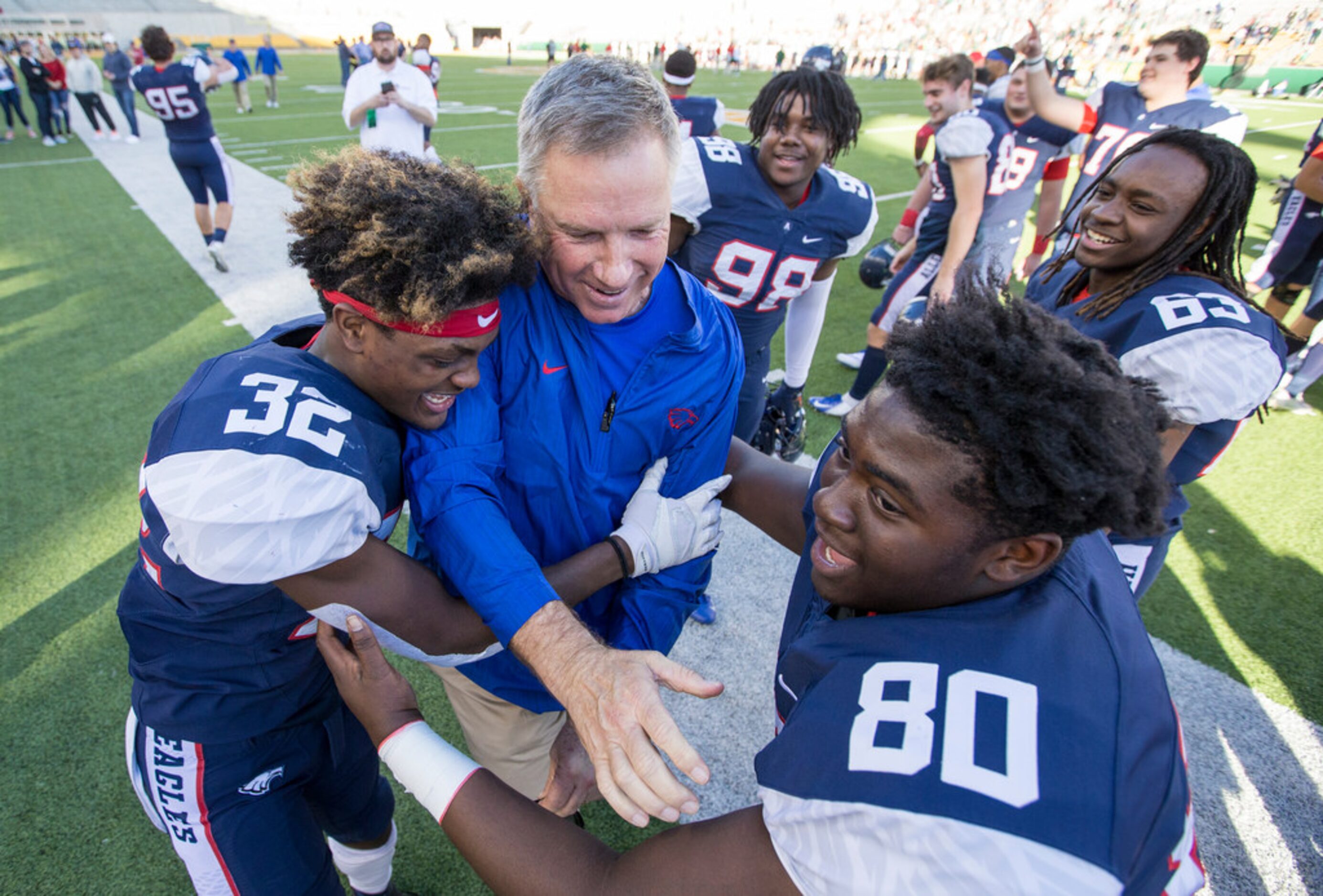 Allen head coach Terry Gambill, center, celebrates with defensive back Zayteak McGhee (32)...