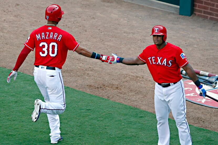 Texas Rangers right fielder Nomar Mazara (30) high-fives third baseman Adrian Beltre after...