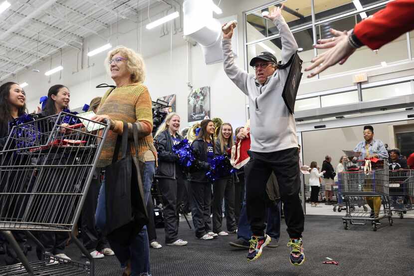 Evelyn Cohen rolls her shopping cart ahead of Josh Ridker as he jumps with excitement...