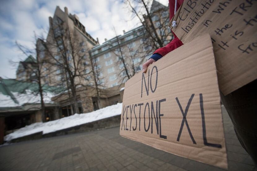 A protester holds a sign outside the hotel where TransCanada CEO Russ Girling was speaking...