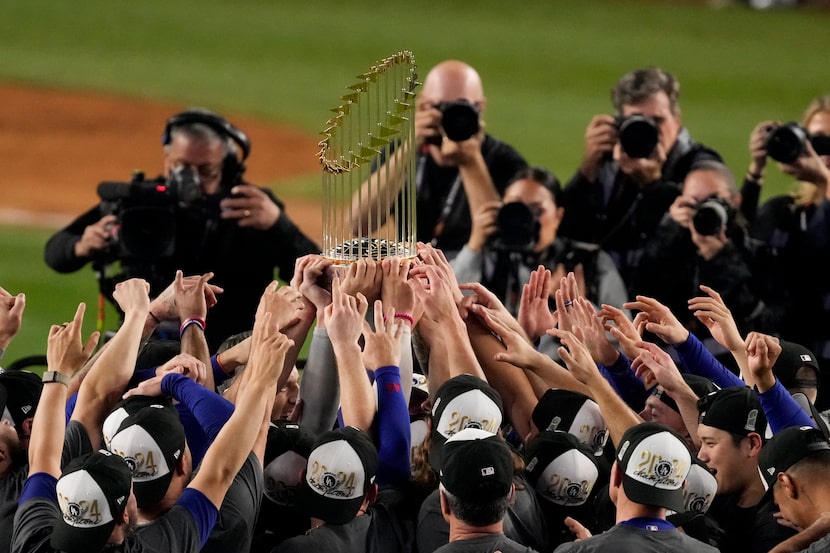 The Los Angeles Dodgers celebrate with the trophy after their win against the New York...